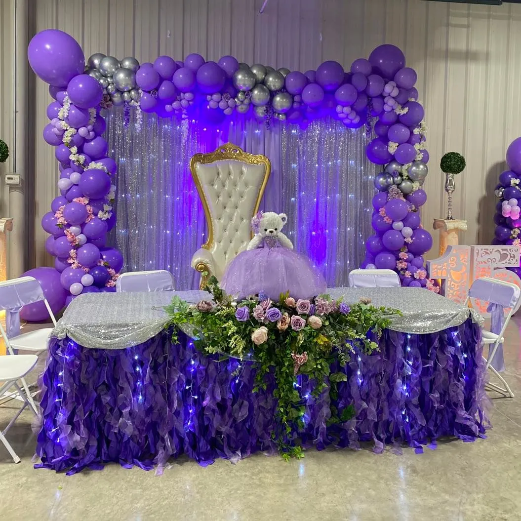 Quinceañera celebration setup with a white-and-gold throne and floral décor