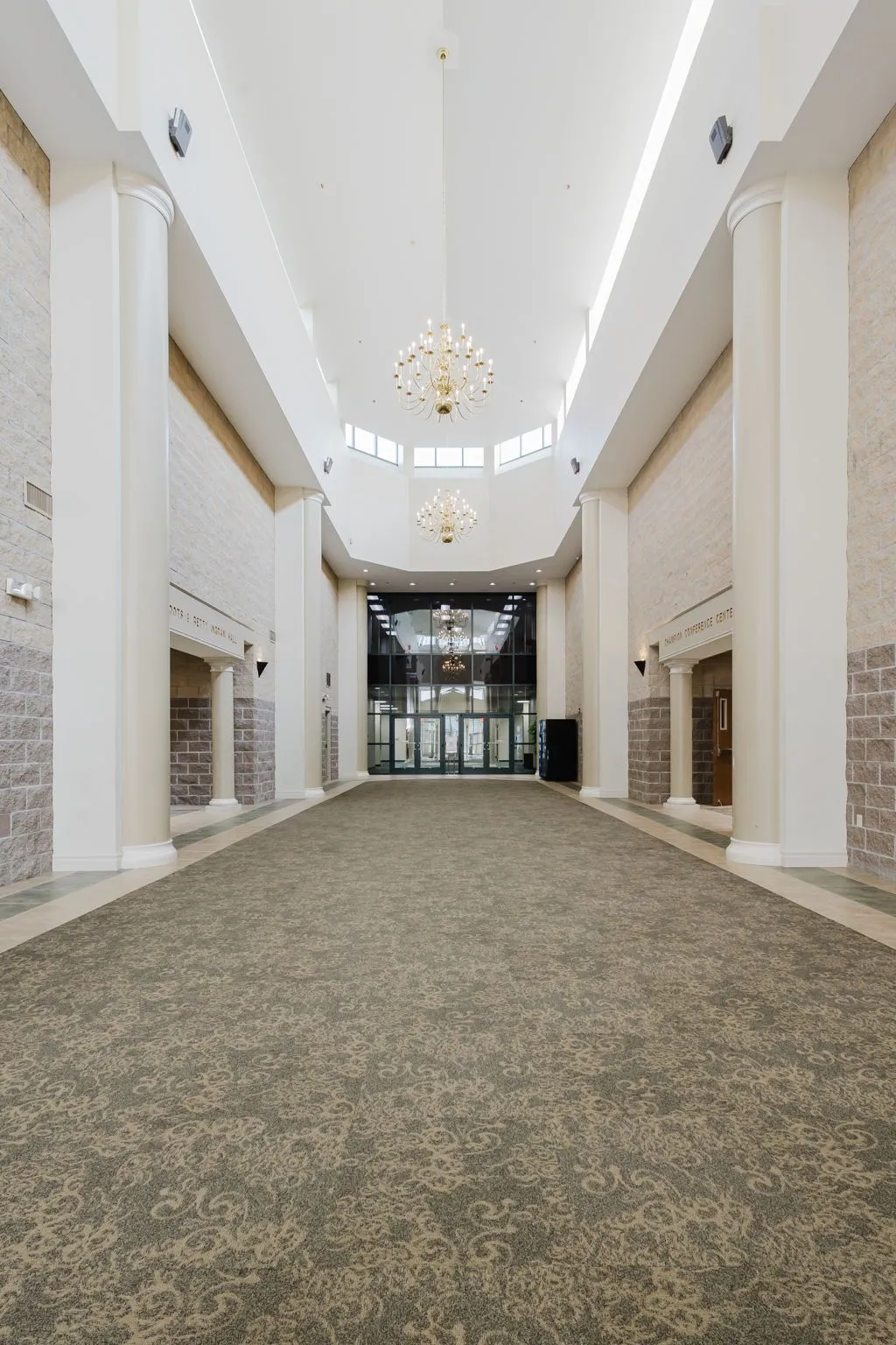 Grand Hall entrance with soaring ceilings, towering columns, and crystal chandeliers